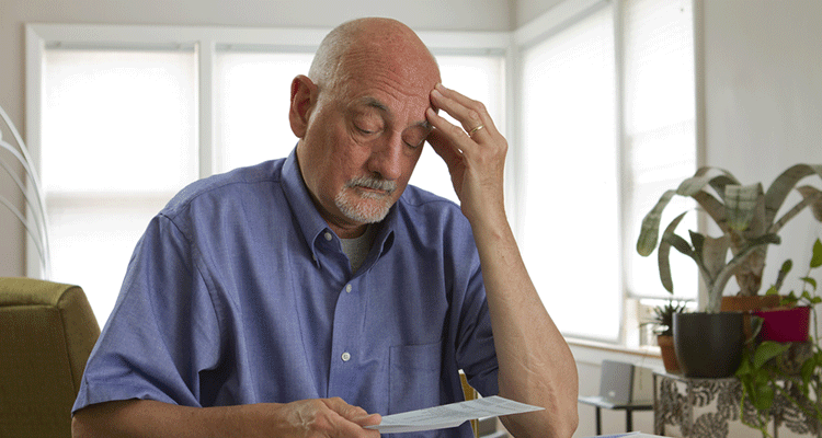 Mature man analyzing bill payments
